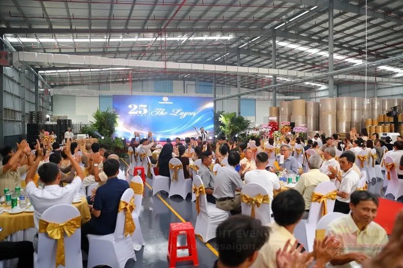 Khách mời tham dự gala dinner doanh nghiệp trong không gian tiệc và sân khấu được bố trí đồng bộ.