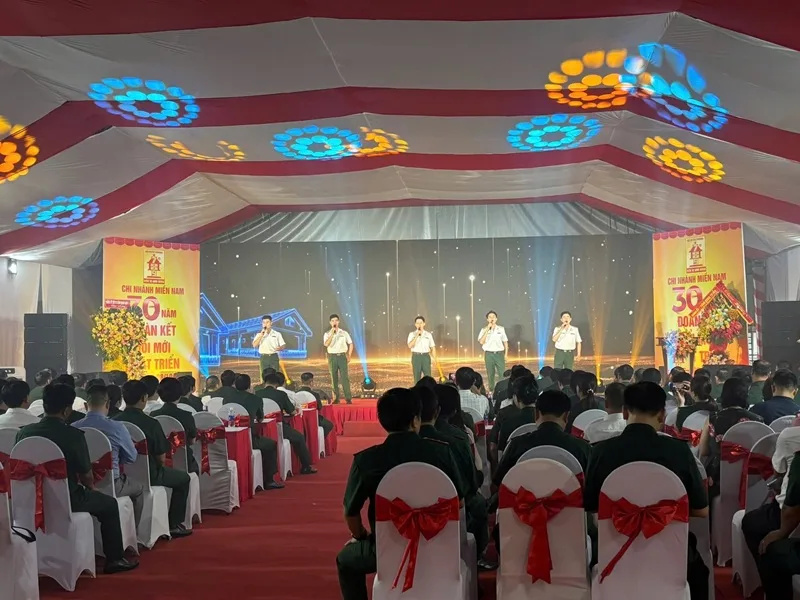 Khách mời tham dự sự kiện doanh nghiệp trong không gian được bố trí sân khấu và ghế ngồi đồng bộ.