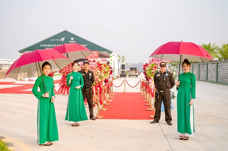 Nhân sự lễ tân đón tiếp khách mời tại lễ khánh thành doanh nghiệp ngoài trời.