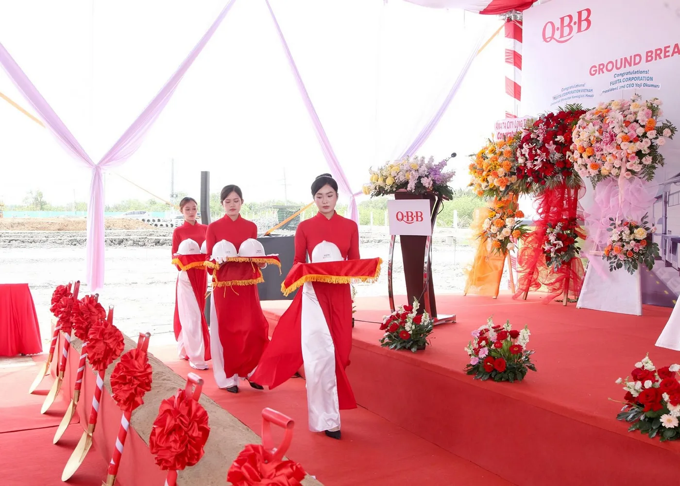 Lễ tân kiểm tra và chuẩn bị vật phẩm trước khi mời đại biểu thực hiện nghi thức Đội ngũ lễ tân chuẩn bị vật phẩm phục vụ nghi thức động thổ trên sân khấu.